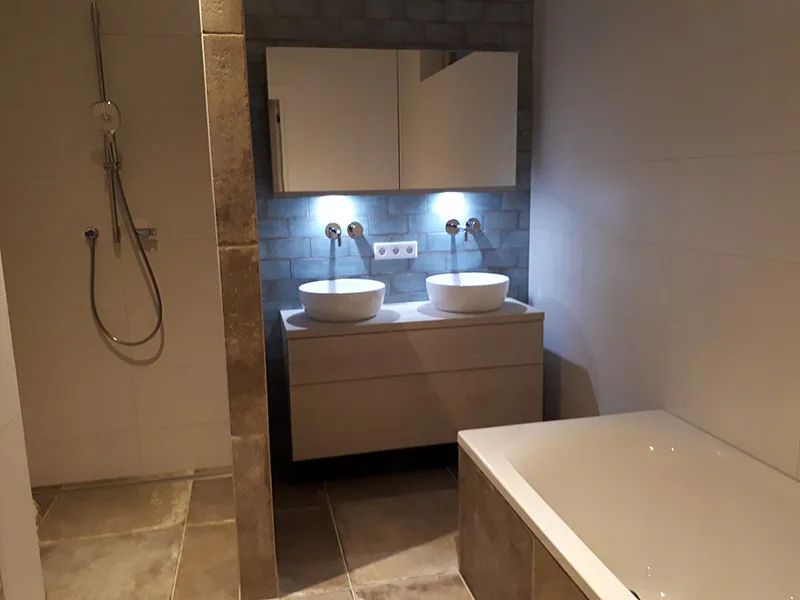 Afgewerkte badkamer met dubbele wastafel en bad